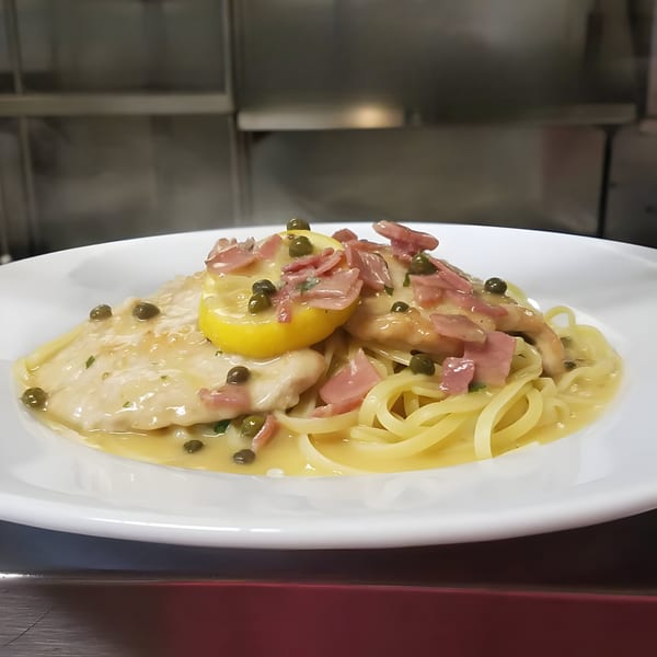 Leone's Chicken Piccata with capers, prosciutto, and lemon slices over linguine pasta.